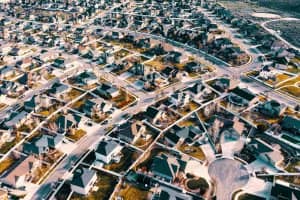 Vogelperspektive auf eine Wohnsiedlung mit Einfamilienhäusern, Vorgärten und geschwungenen Anliegerstraßen