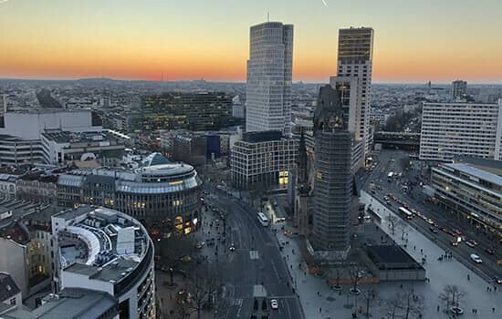 Vogelperspektive auf moderne Bürohochhäuser an belebtem Stadtkreisel mit Glasfassaden im Abendlicht