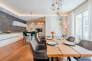 Lichte eetkeuken met parketvloer Eethoek Kookeiland Barkrukken en ramen van vloer tot plafond naar de loggia