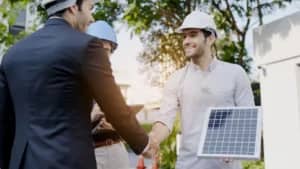 Stretta di mano con modulo solare davanti a un moderno edificio residenziale