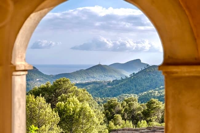 通过圆形拱门欣赏地中海美景 - 位于独特位置的马洛卡小别墅，拥有 5 间卧室、客房和游泳池，待售。