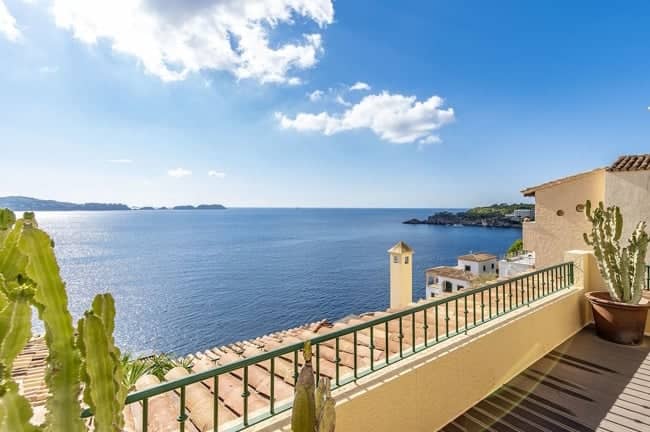 Seeseitige Dachterrassenwohnung mit Balkon und Kakteentöpfen vor Panoramameerblick