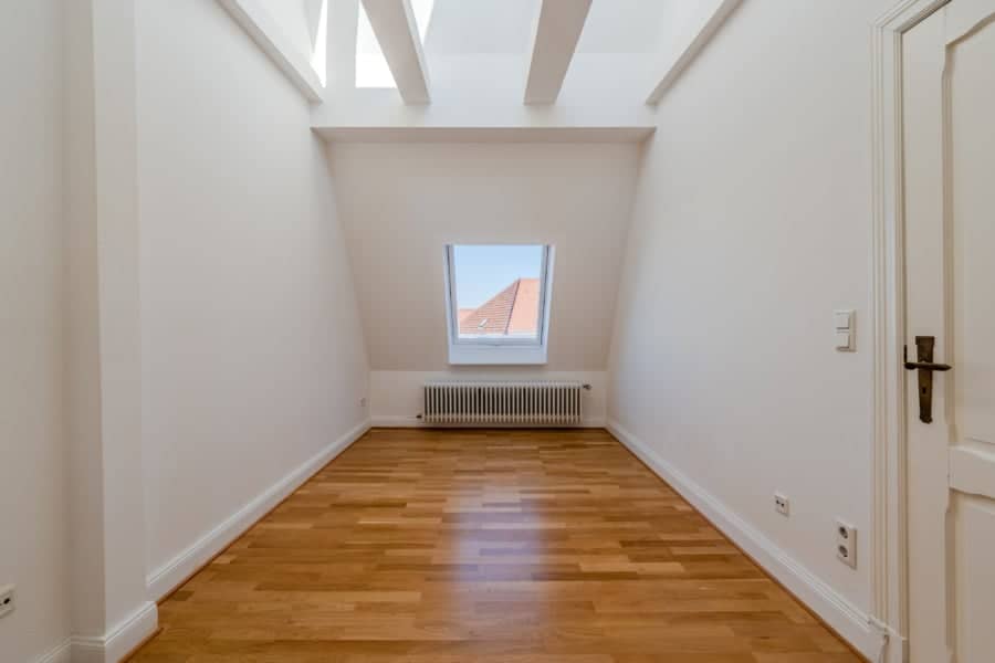 Leeres Dachgeschosszimmer mit Parkett und Dachfenster - Großzügige Dachgeschosswohnung in Steglitz mit Panoramablick