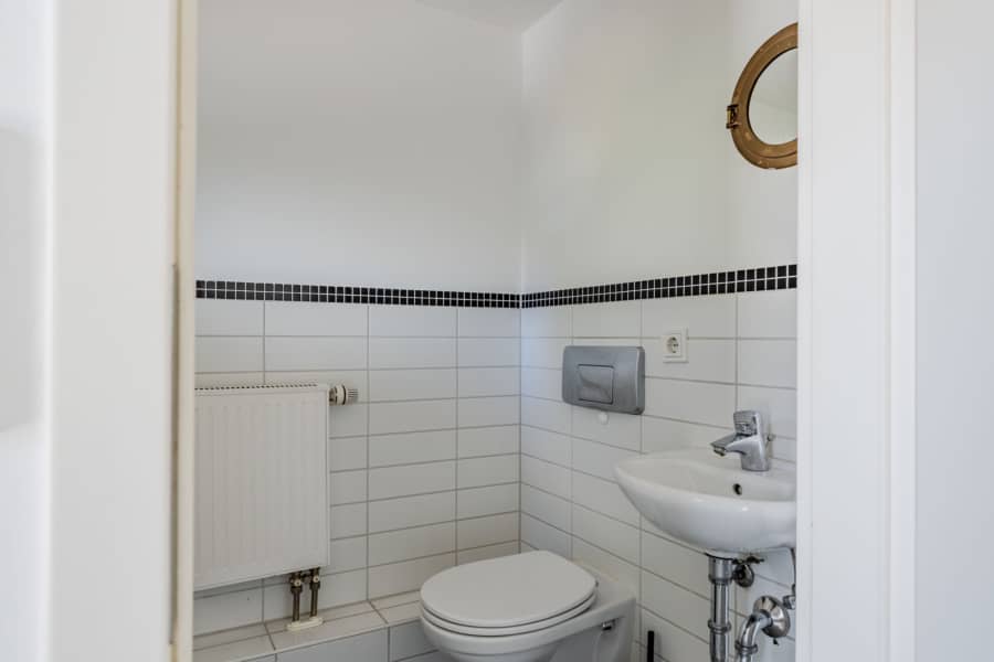 Kompaktes Gäste-WC mit weißer Fliesenausstattung - Bezugsfrei & renoviert 2025: 6-Zimmer-Townhouse an der Rummelsburger Bucht