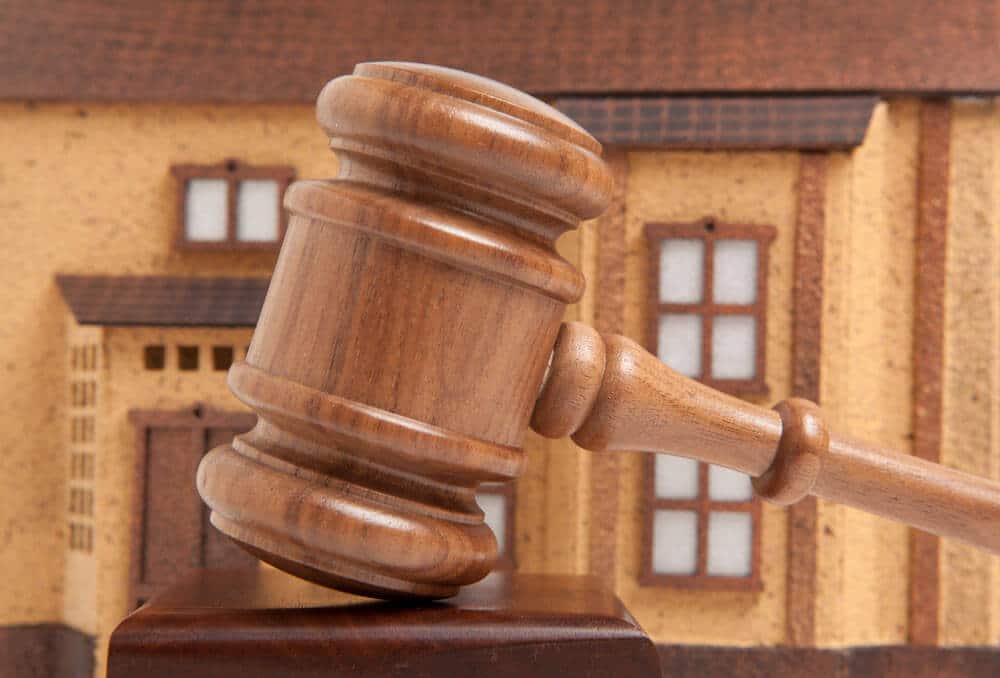 独立式房屋正视图，斜屋顶，前景为拍卖锤