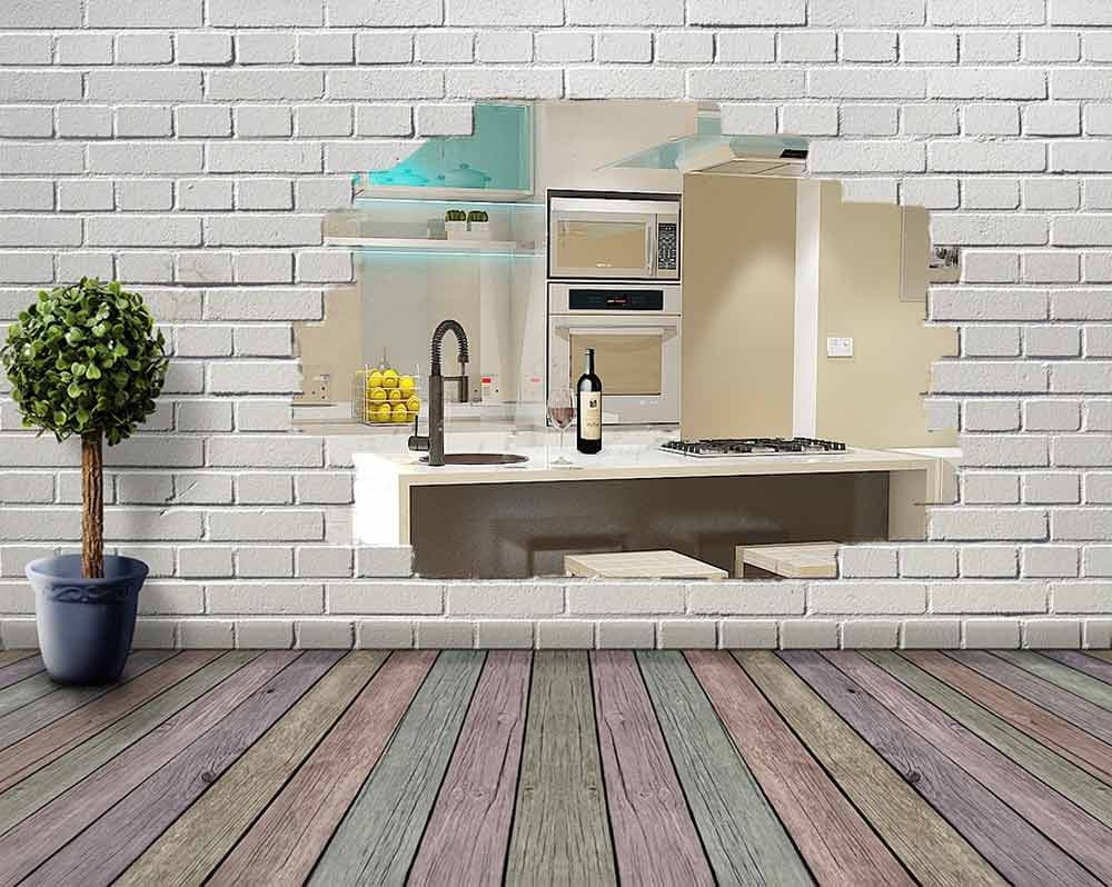 Aufgebrochene weiße Klinkerwand vor buntem Holzboden mit Blick auf moderne Kücheninsel mit Spüle, Tresen und Einbauschränken