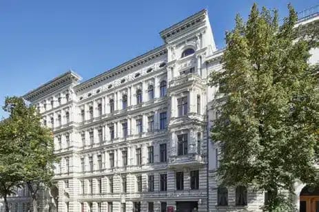 老建筑中的公寓楼，白色粉刷外墙和窗户装饰，从略微倾斜的正面视角拍摄