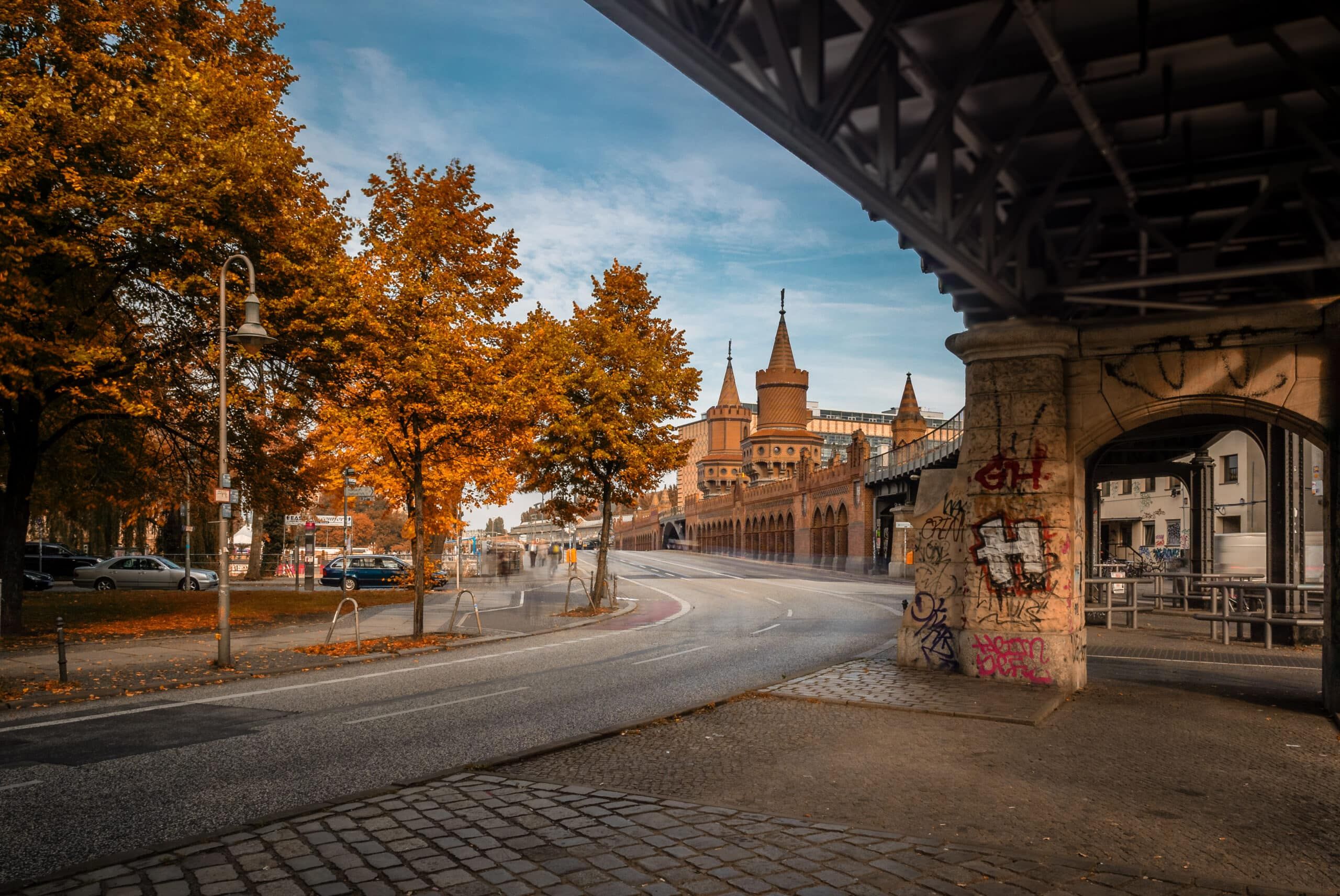 Oberbaumbrücke Berlijn straatperspectief met graffiti gespoten brug ondersteuning herfstbomen op de voorgrond