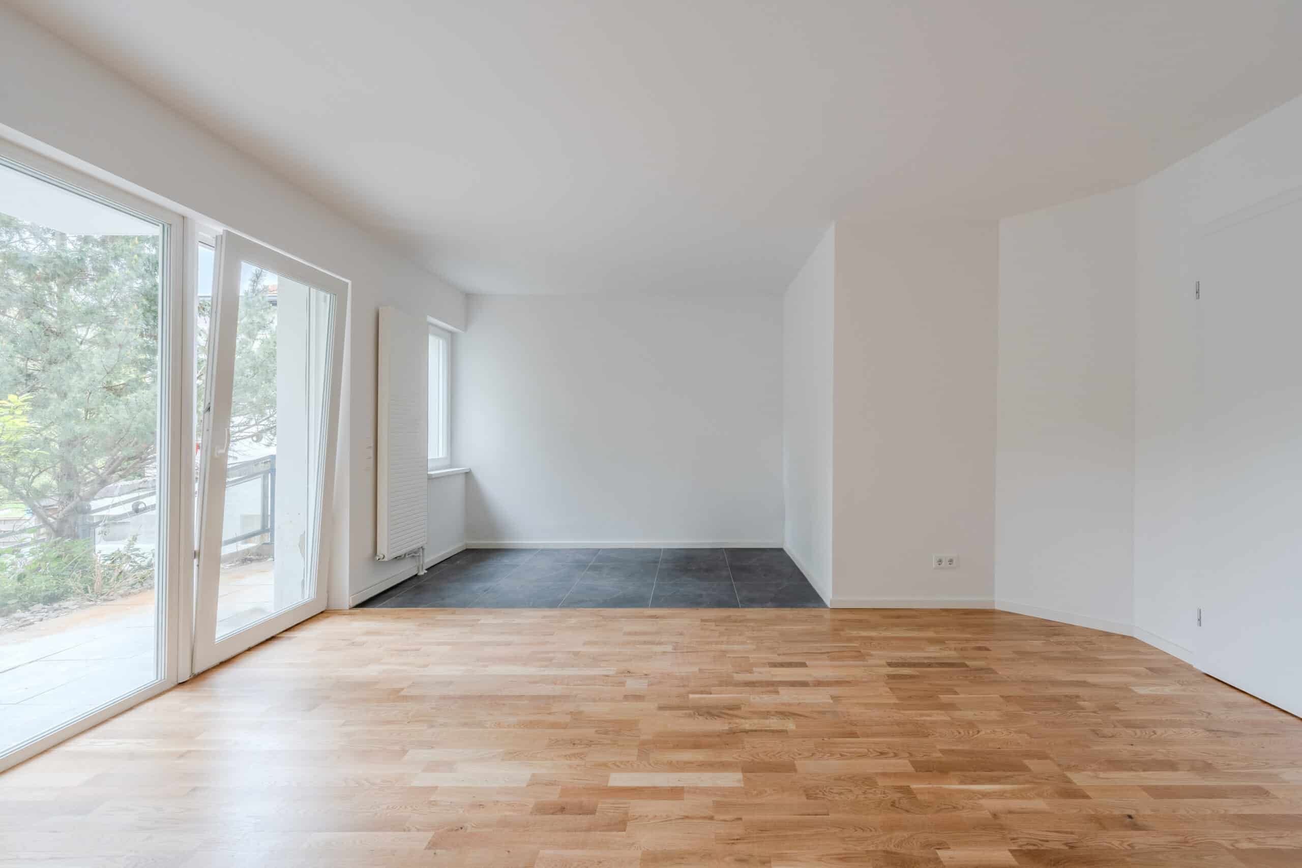 Innenansicht Erdgeschosswohnung mit Parkett- und Fliesenboden bodentiefe Fenster und direktem Terrassenzugang