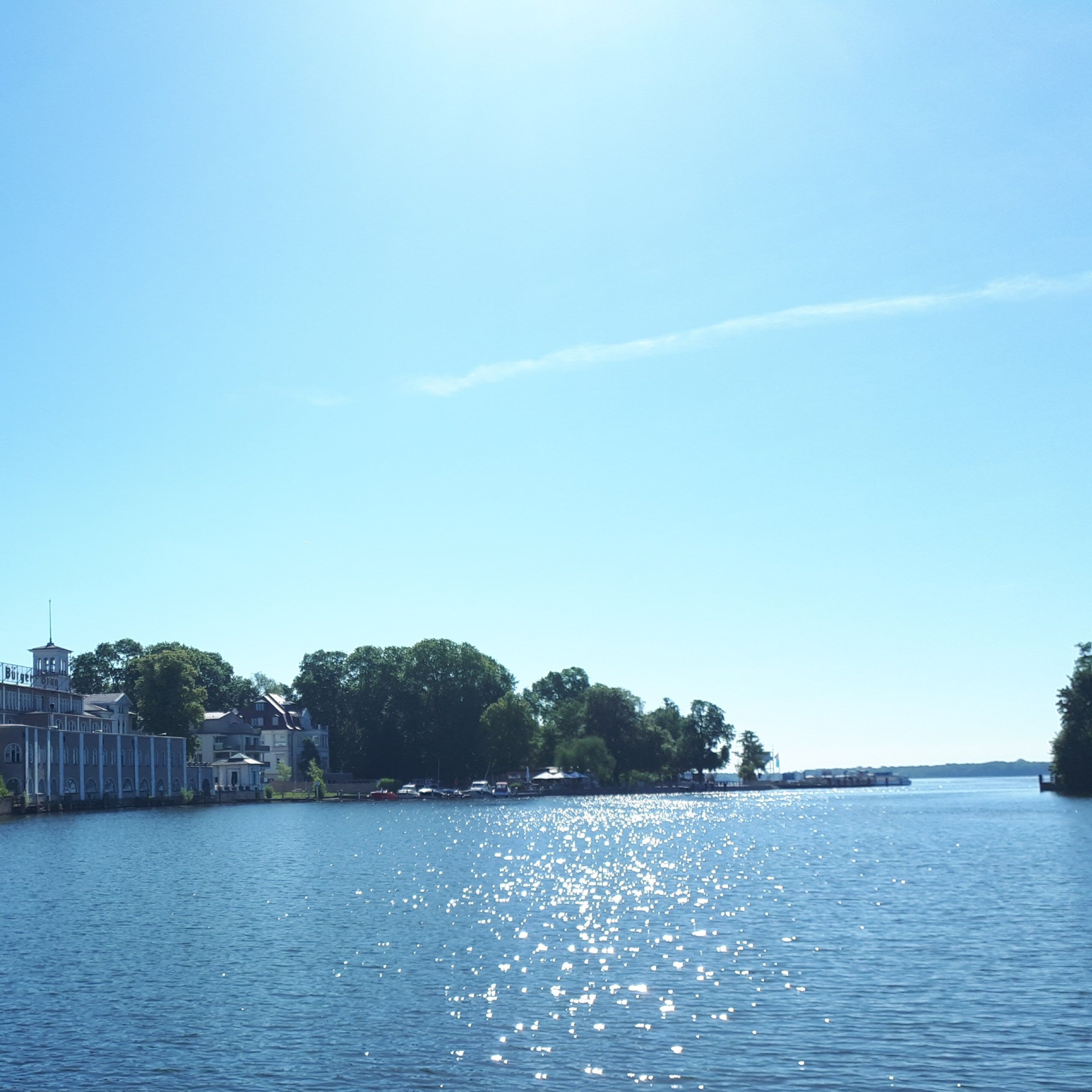 Vista panoramica su un lago tranquillo con la superficie dell'acqua scintillante e le rive boscose