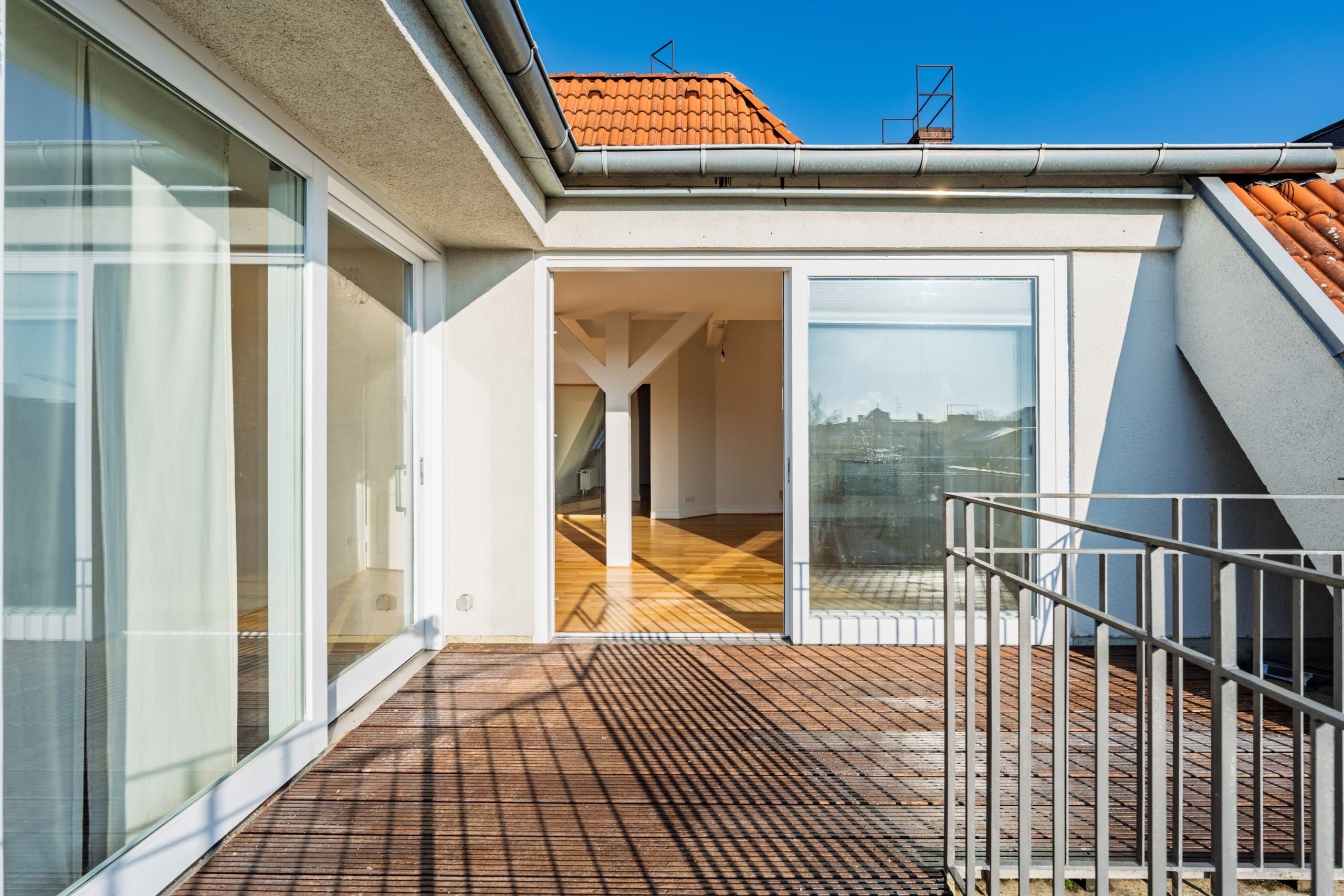 Attico con vista sulla terrazza, pavimento in parquet e ampie porte scorrevoli in vetro, situato all'ultimo piano