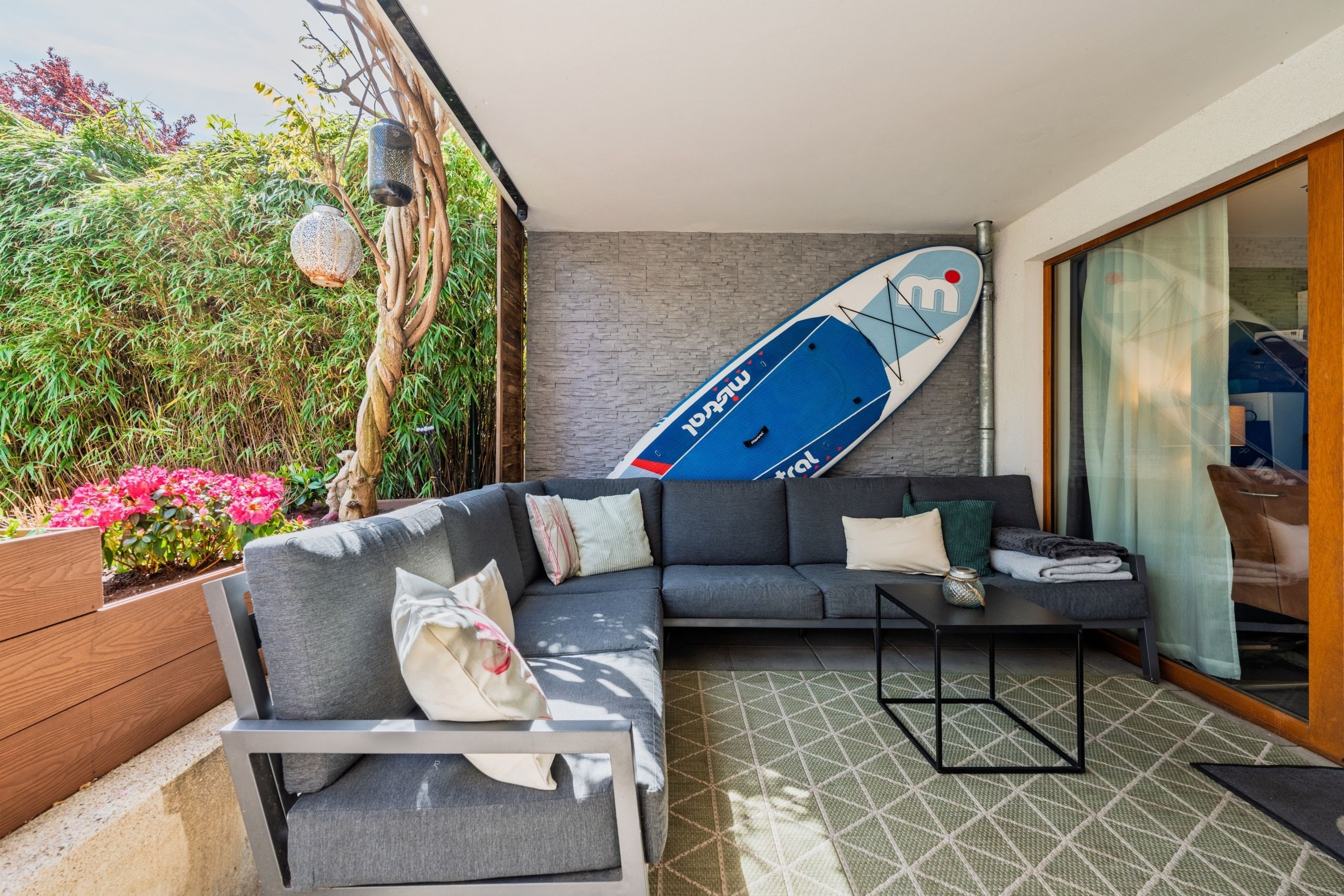 Überdachte Terrasse mit gemütlicher Lounge und geschütztem Außenbereich