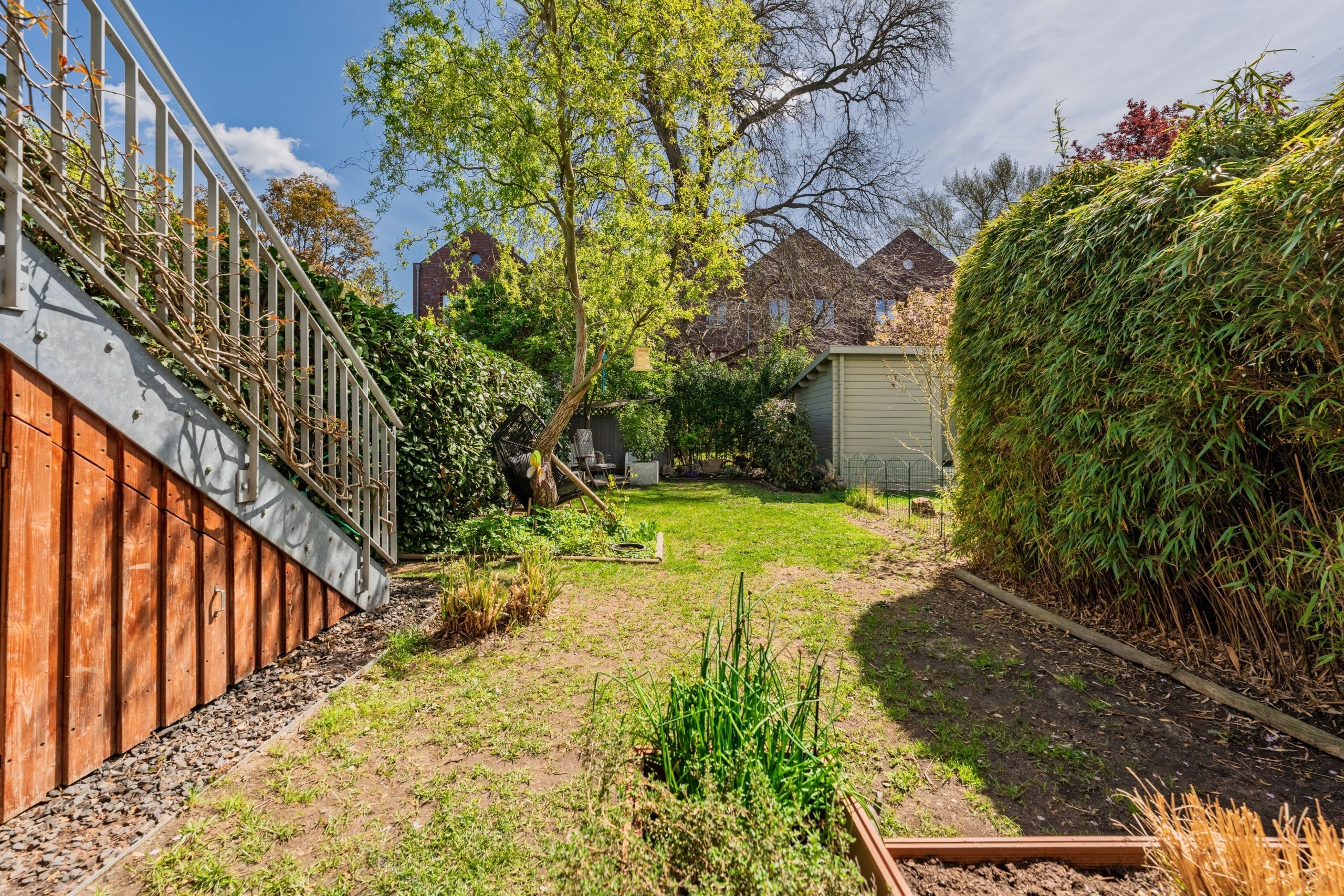 Gepflegter Gartenbereich mit viel Grün und zusätzlichem Stauraum