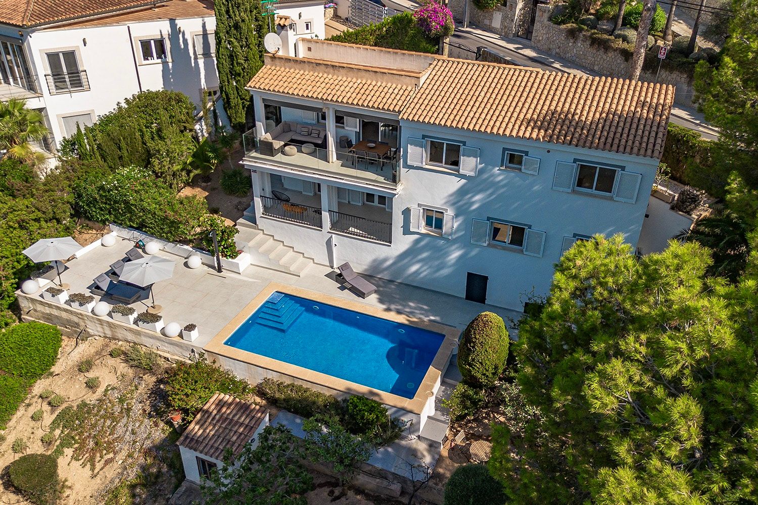 Luchtfoto van een mediterrane villa met een terras van twee verdiepingen en een zwembad in een zonnige tuin