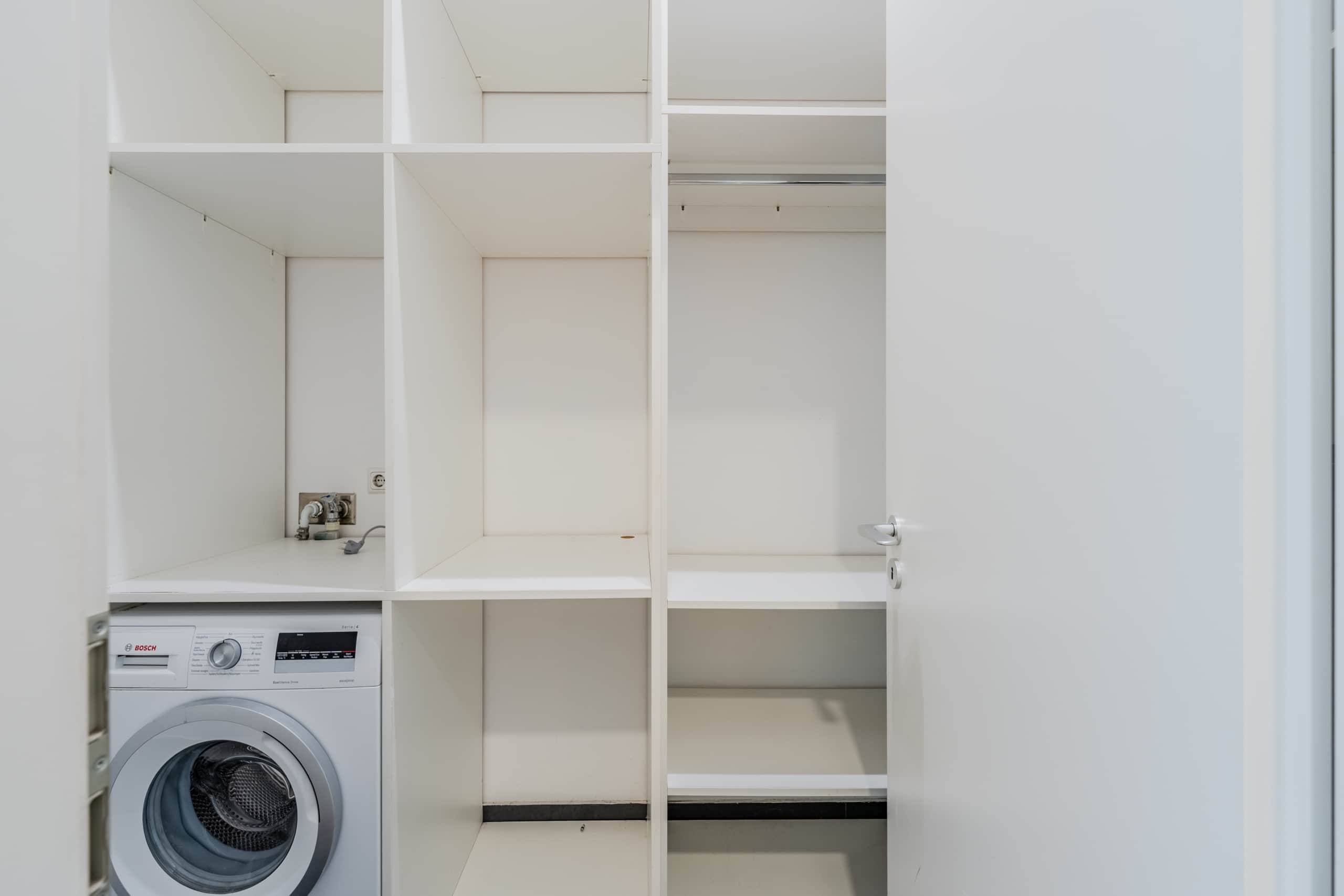 Hauswirtschaftsraum mit weißem Einbauschrank mit offenen Regalfächern und Bosch Frontlader Waschmaschine