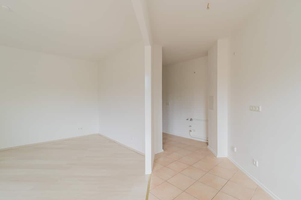 Innenansicht Neubauwohnung mit offener Küchennische weiße Wände Laminatboden und Fliesenbereich