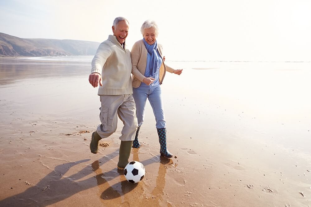 Beach with wet sand and reflecting surf from the side with football