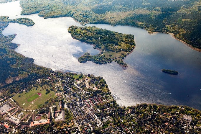 Vue aérienne d'un paysage de lacs avec des maisons individuelles proches de la rive sur une presqu'île et des forêts environnantes