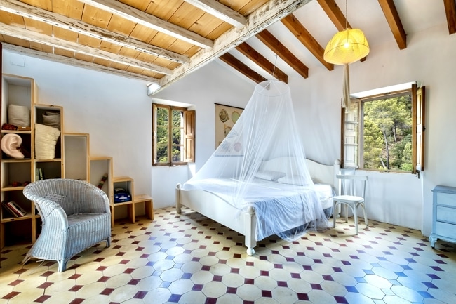 Rustikales Schlafzimmer mit Holzbalken und Fliesenboden - Mallorquinische Finca in einzigartiger Lage mit 5 Schlafzimmern, Gästehaus und Pool zu verkaufen