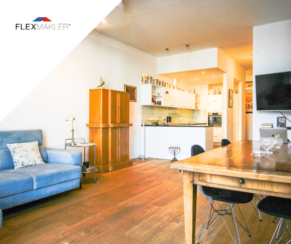 Moderne Wohnung mit offener Wohnküche und Wohnbereich aus Eckperspektive mit Parkettboden und blauer Couch