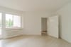 Innenansicht helle Wohnung mit Laminatboden Balkonfenster Heizkörper und offener Zimmertür