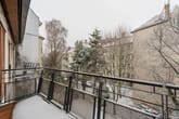 Schneebedeckter Stadtbalkon mit Metallgeländer in moderner Etagenwohnung blick in winterlichen Innenhof