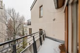 Balkon einer Mehrfamilienwohnung mit Metallgeländer und Schneeablagerung Blick auf benachbarte Gebäude und Winterbäume