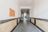 Innenansicht Hauseingangskorridor mit Marmorvertäfelung und Blick durch Doppeltür in Innenhof