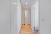 Flur einer modernen Wohnung mit hellem Echtholzdielenboden Einbauschrank weißen Türen und Deckenstrahlern
