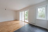 Sala de estar de rés-do-chão ampla com janelas do chão ao teto, acesso ao terraço, piso em parquet e azulejos cinza escuro