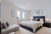 Interior de um quarto moderno com cama estofada, divã e grande janela panorâmica