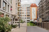 Perspetiva do pátio interior sobre apartamentos modernos com varandas e fachadas de tijolo, e um pátio interior com vegetação