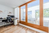 Heller Arbeitsbereich mit großer Fensterfront und Zugang zur Dachterrasse