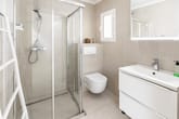 Innenansicht modernes Badezimmer mit bodengleicher Glasdusche wandhängendem WC und LED-beleuchtetem Spiegel
