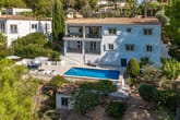 Einfamilienhaus in Hanglage aus Vogelperspektive mit Pool, Loungebereich, überdachtem Balkon und mediterranem Garten