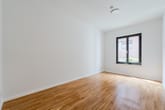 Leerstehendes Zimmer mit hellem Parkettboden Innenperspektive weiße Wände Rauchmelder an Decke Fenster zur Klinkerfassade