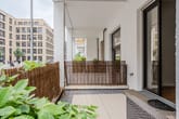 Terrassenansicht Erdgeschosswohnung mit Sichtschutz und Blick auf moderne Klinkerfassade