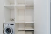 Hauswirtschaftsraum mit weißem Einbauschrank mit offenen Regalfächern und Bosch Frontlader Waschmaschine