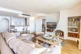 Innenansicht Wohnung Wohnzimmer mit Ecksofa Holzboden Kamin Einbauregal und Barbereich