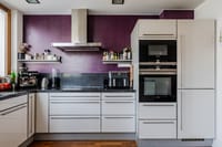 Cocina moderna empotrada con líneas limpias y electrodomésticos de alta gama