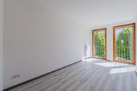 Ruhiges Schlafzimmer mit viel Tageslicht und Blick ins Grüne