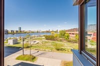 Blick über Grünflächen zur Uferpromenade und zum Wasser