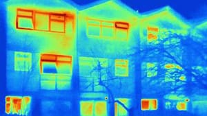 Thermografische Frontansicht eines dreigeschossigen Mehrfamilienhauses mit Satteldach und mehrfachen Fenstern