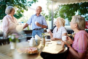 Buitenaanzicht van een café met overdekt terras en houten tafels
