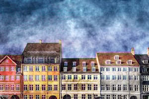 Frontale Ansicht mehrerer viergeschossiger Reihenhäuser mit bunten Putzfassaden und Satteldächern mit Dachgauben