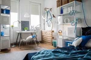 Perspectiva interior de un dormitorio moderno de adolescente con escritorio, bicicleta de pared y estantería de pared abierta