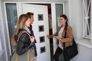 Вид спереди на дом с белой входной дверью с четырьмя квадратными оконными вставками и боковыми стеклянными полосами