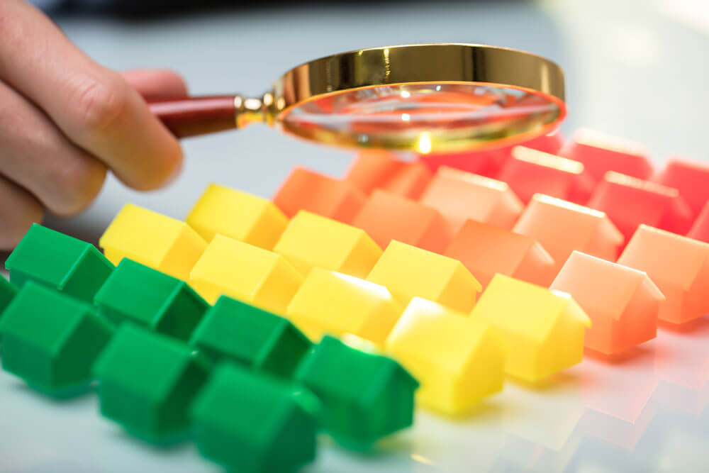 Gros plan de maquettes de maisons colorées sous la loupe sur un fond blanc