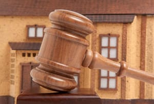 独立式房屋正视图，斜屋顶，前景为拍卖锤