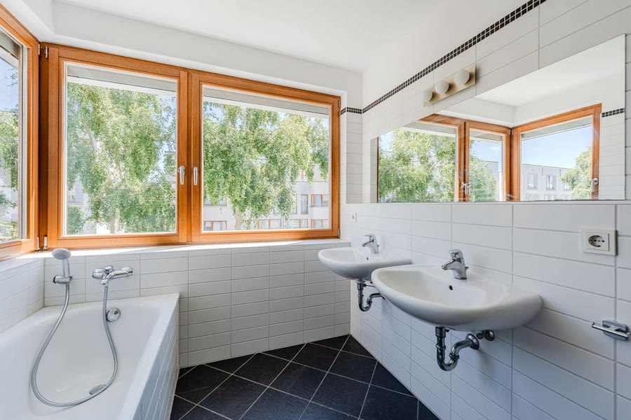 Modernes Apartmentbad mit großen Holzfenstern - Bezugsfrei & renoviert 2025: 6-Zimmer-Townhouse an der Rummelsburger Bucht